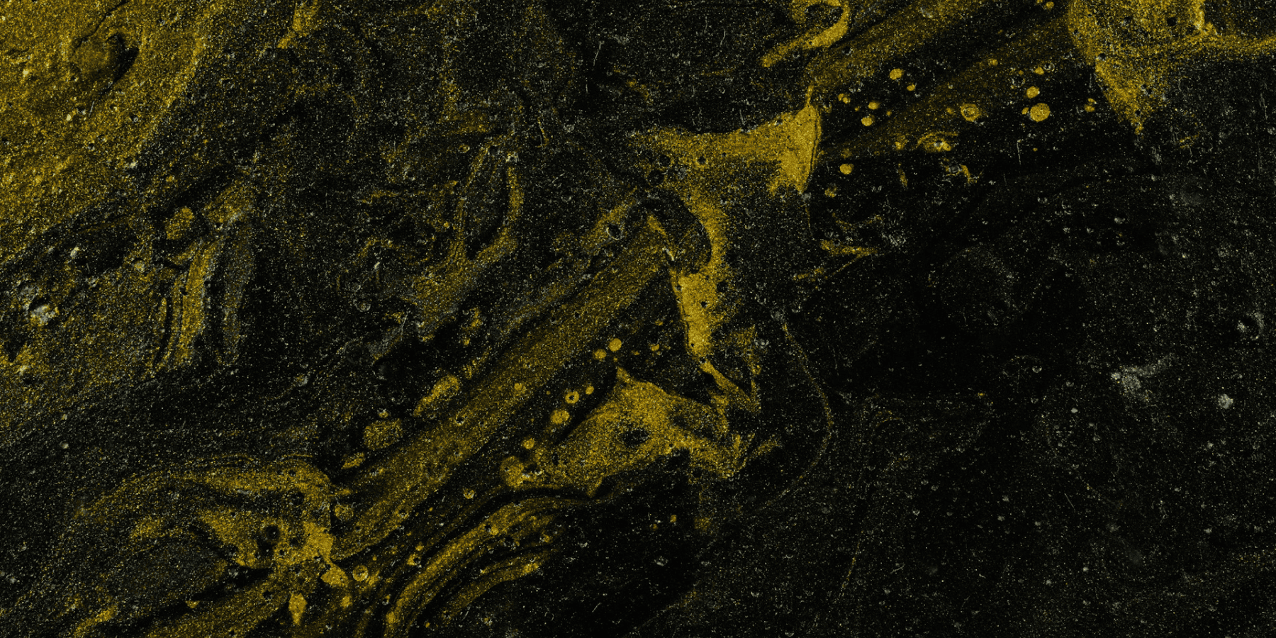 Close-up of a textured surface with yellowish patterns on a dark background
